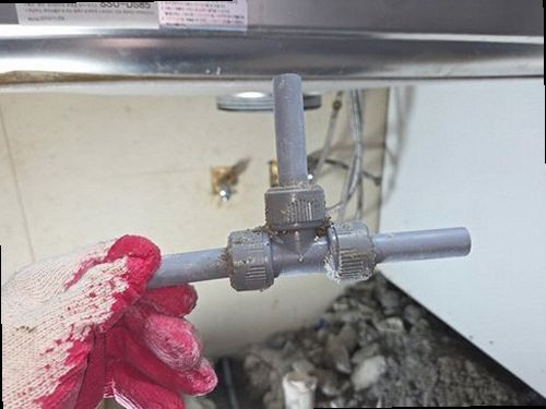 단원구 누수탐지 싱크대 옆 벽면의 변색과 하부장 내부 습기를 확인하는 모습